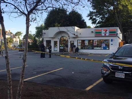 Outside the 7-Eleven on Centre Street at about 7 a.m. Saturday, the parking lot was almost entirely cordoned off by yellow police tape, and three uniformed officers stood conversing in the center of the lot. 
